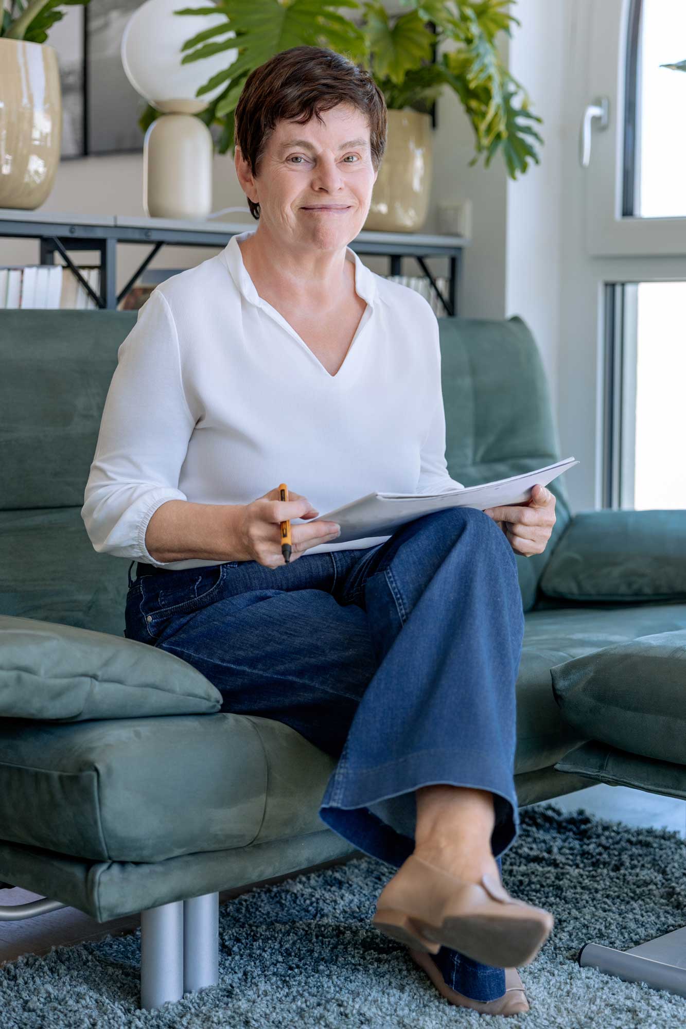 Sabine Peipe sitzt mit Unterlagen in der Hand